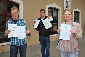 Drei junge Menschen zeigen die Urkunde des Schreibwettbewerbs der "Wortfinder"
